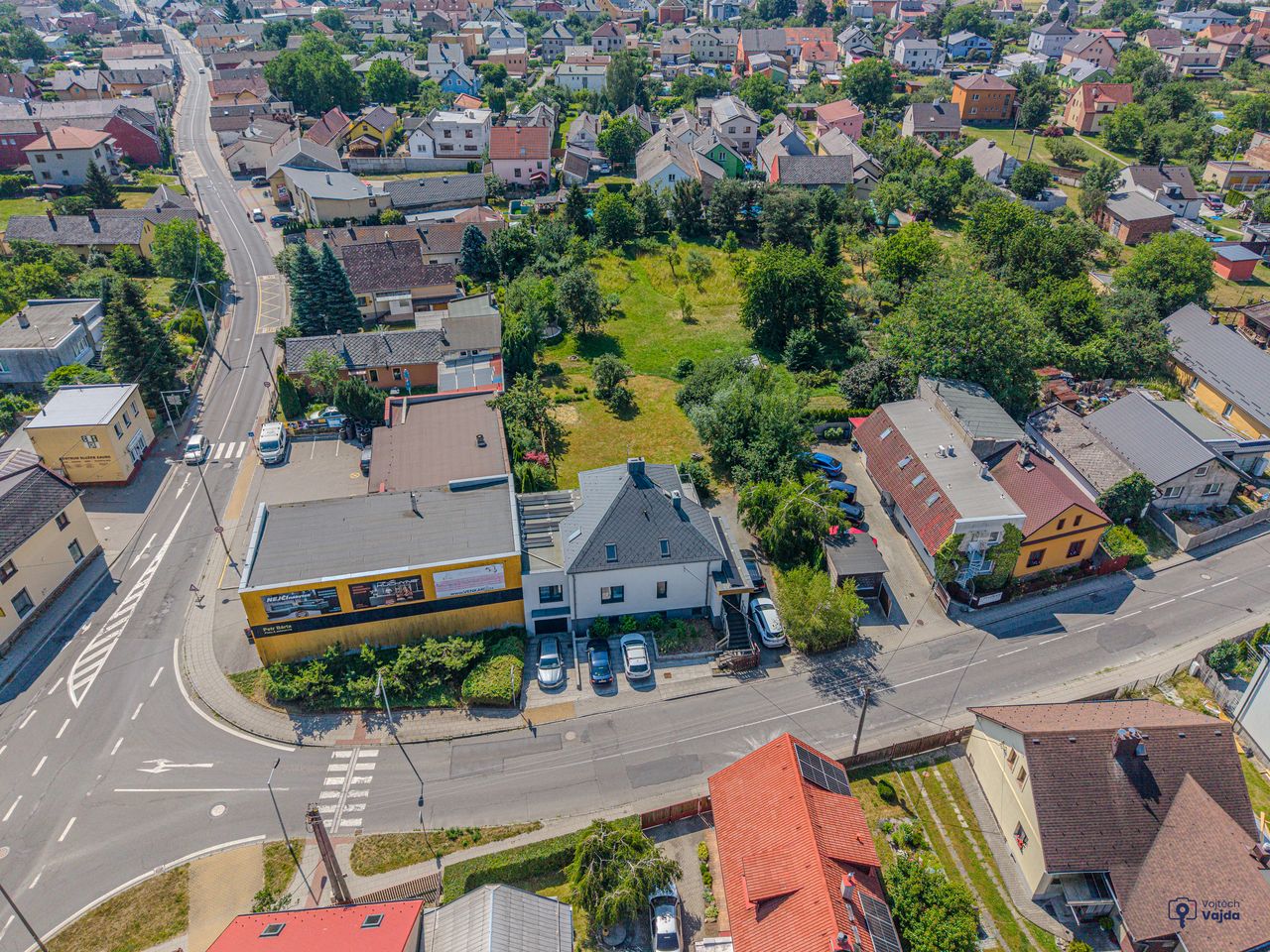 Dům u ulice a za ním zelená plocha zahrady a pozemků