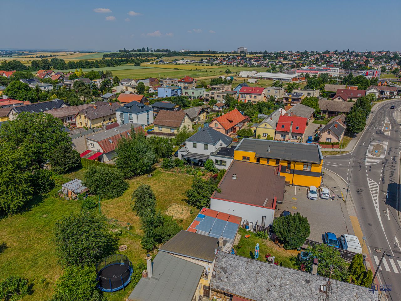 Šikmý letecký pohled na dům, zahradu a okolní domy