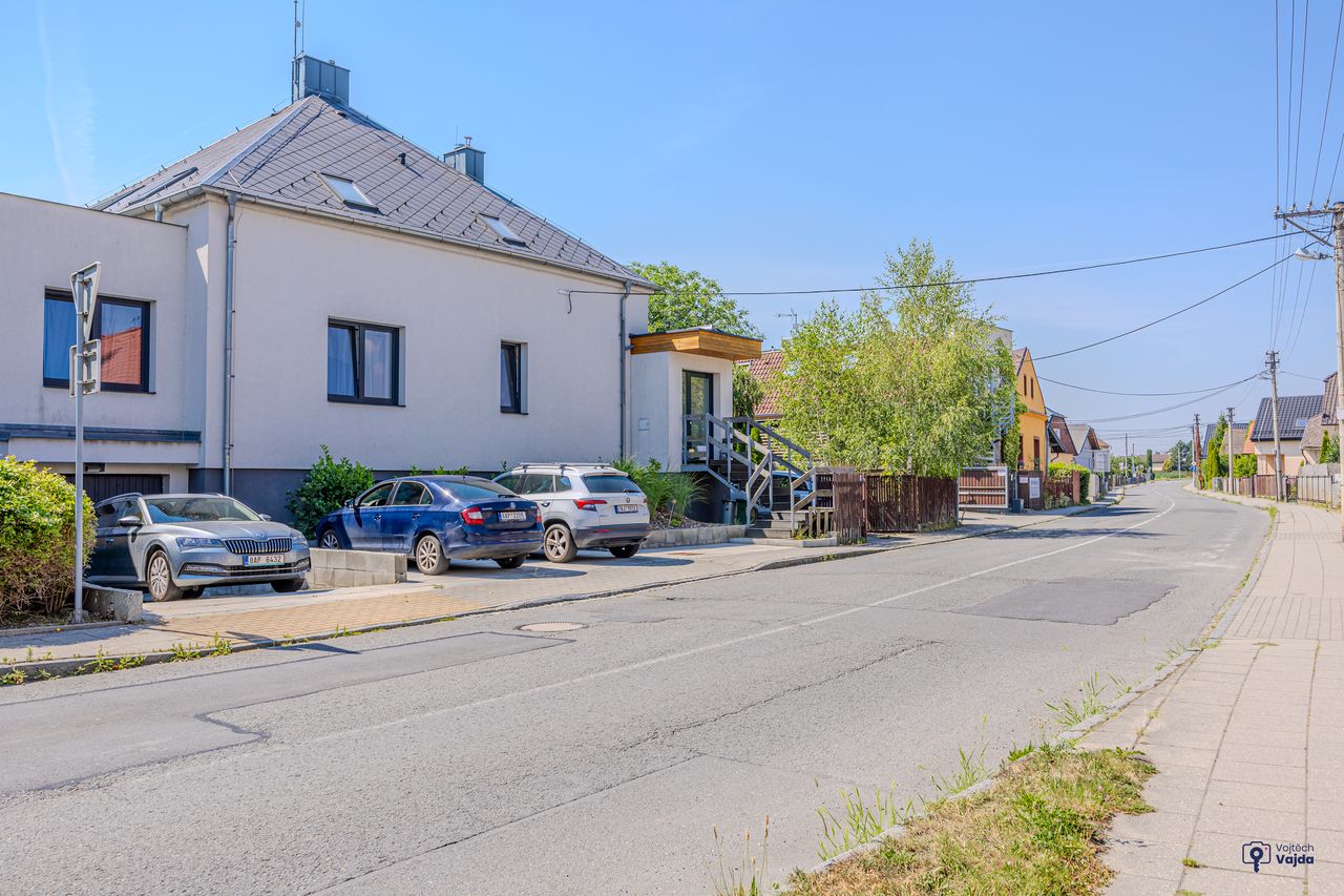 Auta zaparkovaná podél domu u ulice